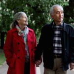 Older couple walking in park