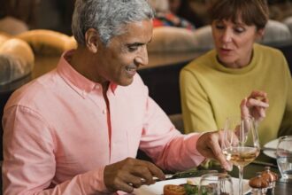 Mature couple in a discussion while eating a meal in a restaurant.