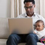 Father working from home and taking care of baby