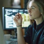 Young female analyst working at her desk in the office