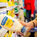 Lady taking a bottle of Hellmann's Real Mayonnaise from a supermarket shelf